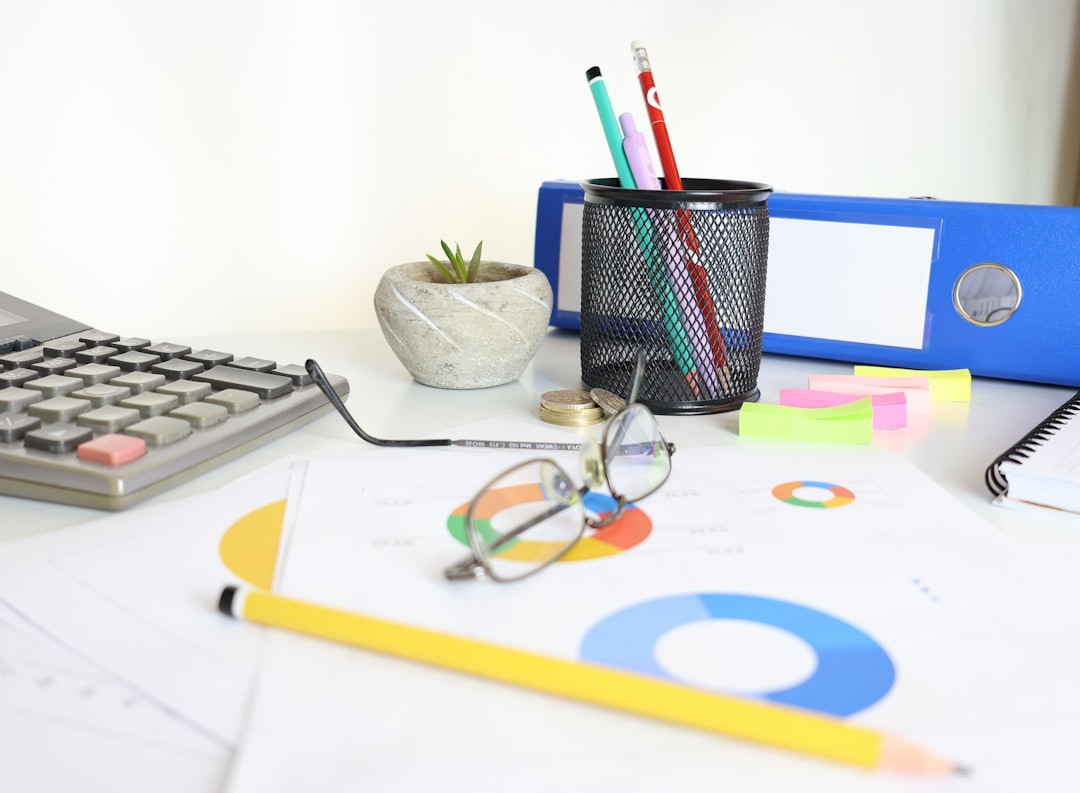 Kalkulator obok dokument&oacute;w księgowych z gadżetami reklamowymi